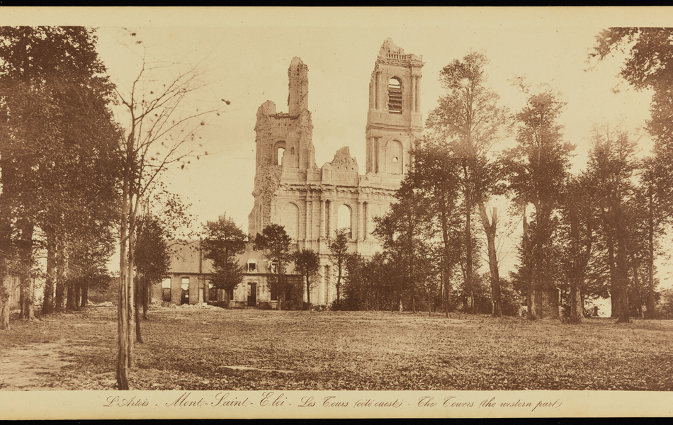 Photographie sépia montrant un parc arboré devant les ruines de deux tours.