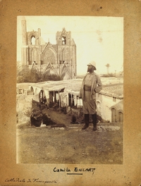 Photographie noir et blanc montrant un homme posant devant un édifice religieux.