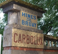 Photographie couleur montrant une entrée en béton sur laquelle est inscrit "Mines de Bruay. Carbolux".