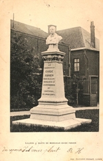 Photographie noir et blanc d'un piédestal sur lequel repose le buste d'Ovide Fanien. Sur le socle, on peut lire: "Au bienfaiteur Ovide Fanien, maire de Lillers, chevalier de la légion d'honneur, ses concitoyens reconnaissants". Le monument se trouve sur une pelouse devant une maison.