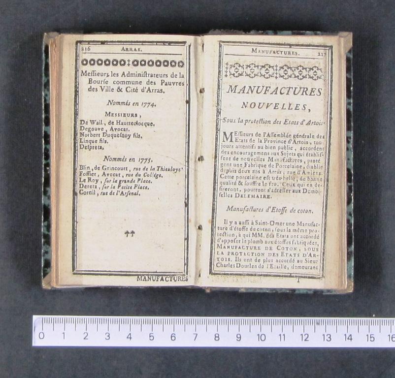 Livre imprimé ouvert sur une double page. En dessous, une règle indique qu'il mesure 14 centimètres.