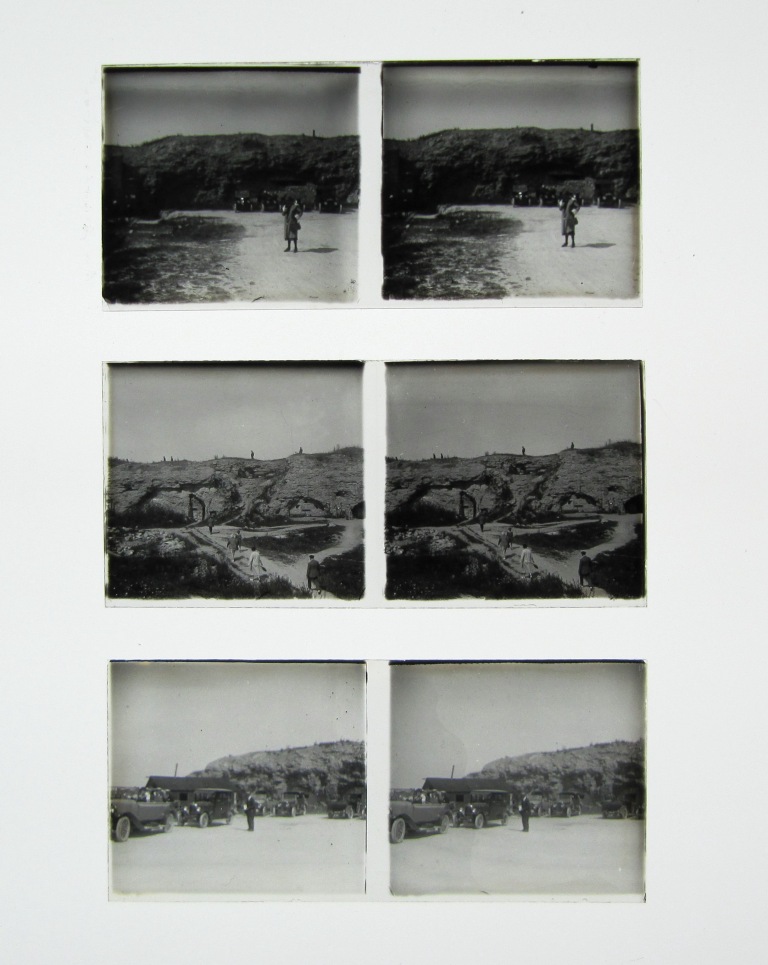 Trois plaques de verre posées les unes sous les autres. Chacune montre une photo en double ; sur la première, on voit une femme sur une plage, sur la deuxième l'ascension d'un groupe de personnes sur un talus et sur la troisième un homme devant des voitures.