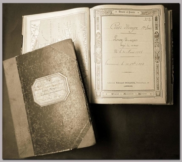 Photographie couleur d'une couverture et d'une page de garde de cahier d'écolier. On lit "Cours moyen. 1ère année. Leroy François, âgé de 10 ans. Né le 30 mars 1888. Commencé le 14 décembre 1998"