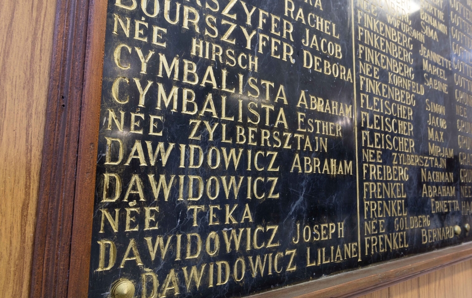 Photographie couleur montrant une plaque commémorative sur laquelle sont gravés des noms de personnes.