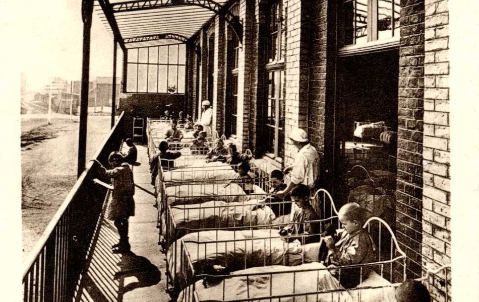 Carte postale noir et lbanc montrant une pergola sous laquelle on a installé des enfants alités.