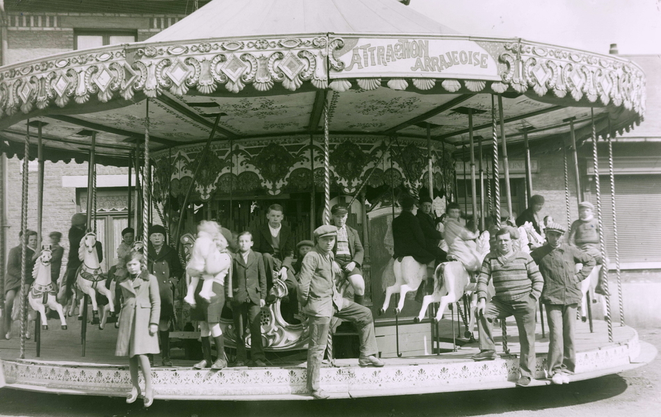 Photographie noir et blanc montrant un carrousel avec des enfants.