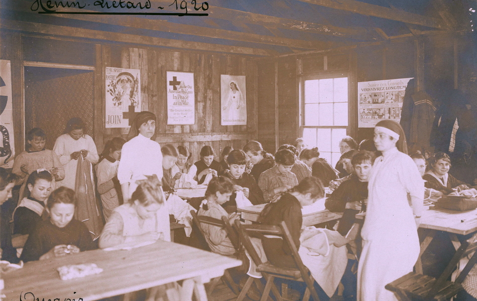 Photographie noir et blanc montrant des fillettes dans une salle de classe, occupées à des travaux de couture.