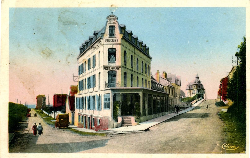 Carte postale couleur de deux rues menant à la mer. Au croisement, se tient une grande bâtisse sur laquelle on lit "Fouquet. Restaurant"