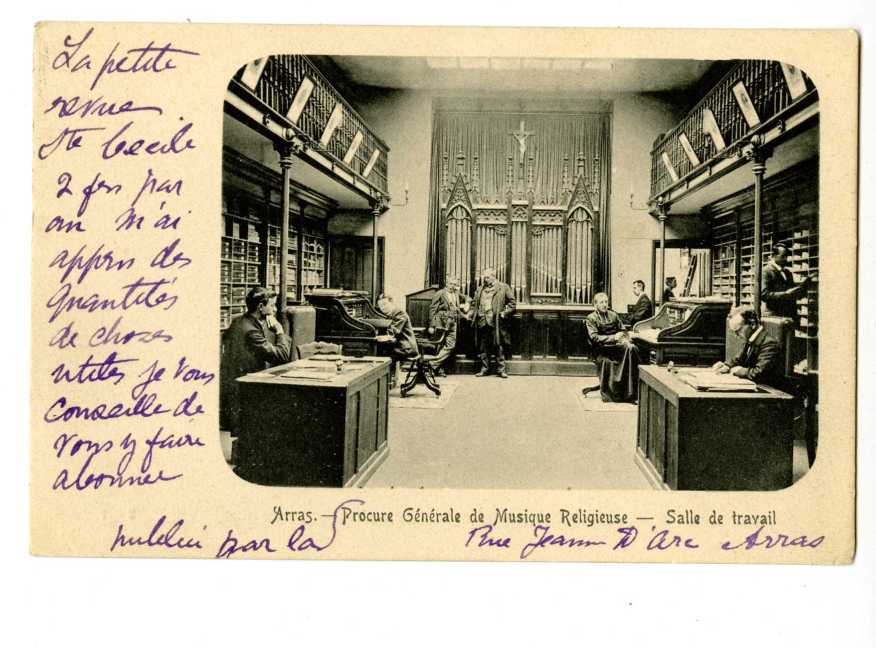 Carte postale noir et blanc portant cette inscription manuscrite "La petite revue Ste Cécile deux fois par an m'a appris des quantités de choses utiles, je vous conseille de vous y faire abonner". La légende de l'image est enrichie de la même manière "Arras. Publié par la Procure Générale de Musique Religieuse, rue Jeanne d'Arc, Arras". La légende ajoute qu'il s'agit d'une salle de travail. Au-dessus on voit une salle aux murs tapissés de casiers et meublée de bureaux occupés. Tout au fond, se trouve un orgue. 