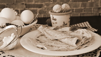 Photographie sépia montrant des crêpes dans une assiette.